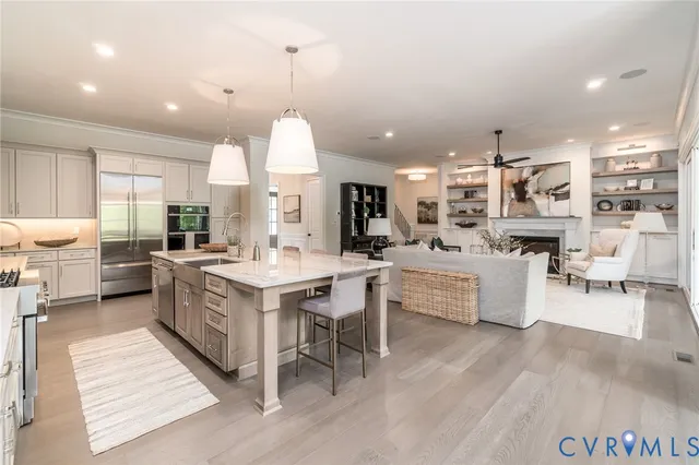 a large white kitchen with lots of counter space a sink appliances and a large window