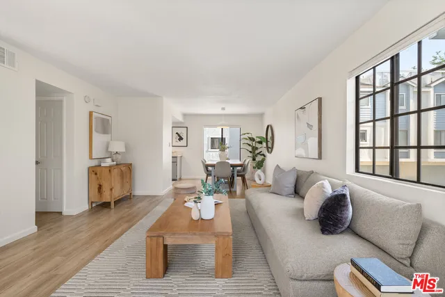 a living room with furniture wooden floor and a large window