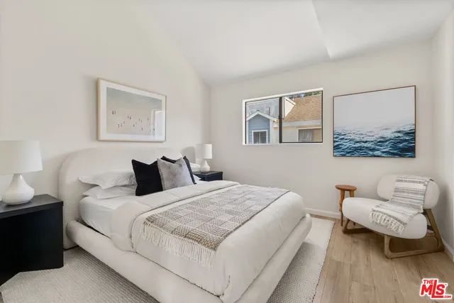 a bedroom with a bed and a painting on the wall