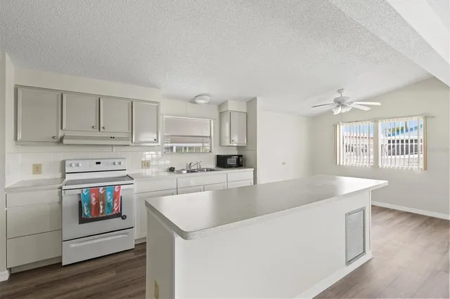 a kitchen with stainless steel appliances granite countertop a sink a stove and a refrigerator