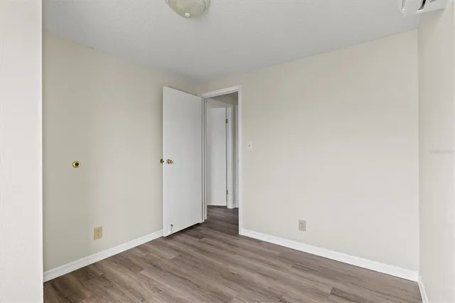 a view of empty room with wooden floor and window