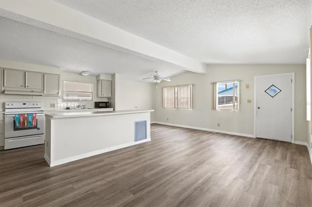 a view of a kitchen with wooden floor and electronic appliances
