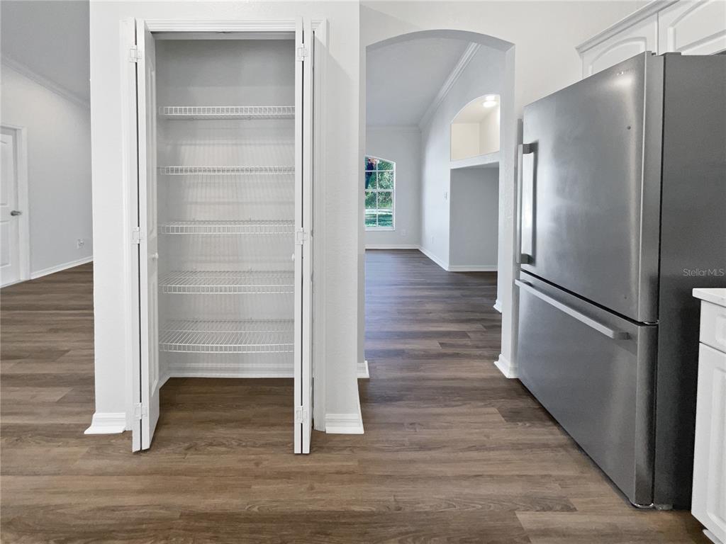 3053 Draper Terrace North Port, FL 34286 - Photo 23 of 31 a kitchen with a refrigerator and wooden floor