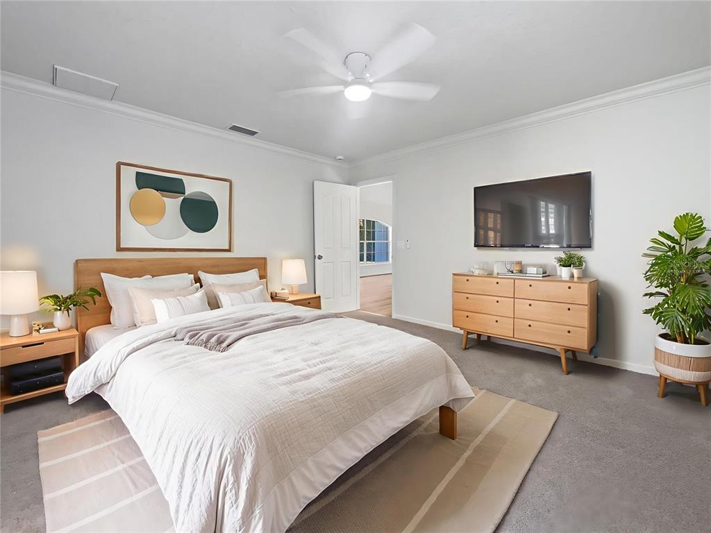 3053 Draper Terrace North Port, FL 34286 - Photo 4 of 31 a spacious bedroom with a bed a couch and a potted plant