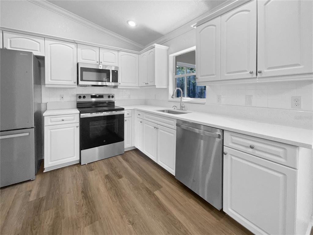 3053 Draper Terrace North Port, FL 34286 - Photo 6 of 31 a kitchen with stainless steel appliances granite countertop a sink a stove a refrigerator and cabinets