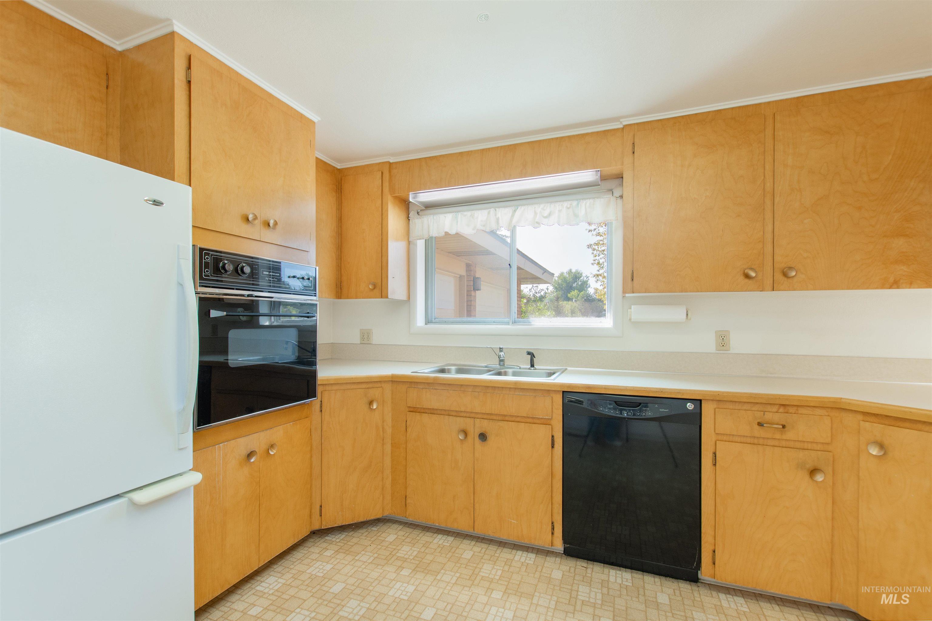 2716 North Redway Road Boise, ID 83704 - Photo 12 of 36 Light wood-finish cabinetry, built-in wall oven, double basin sink, and a black dishwasher