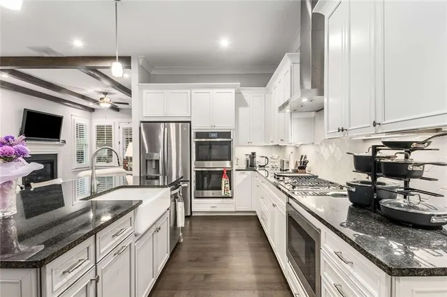 a kitchen with granite countertop appliances cabinets and wooden floor