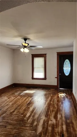a view of an empty room with window and wooden floor