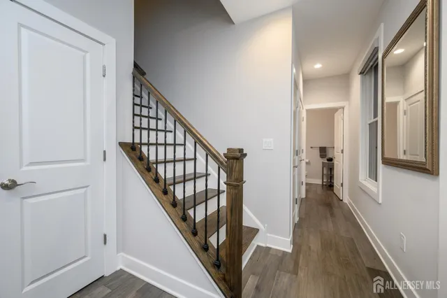 a view of a hallway with wooden floor and staircase