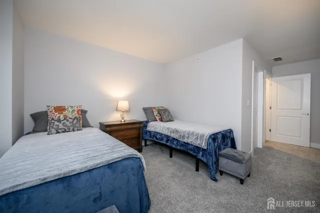 a bedroom with a bed chair and dresser