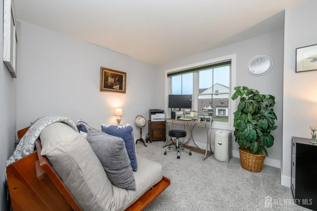 a view of a livingroom with workspace and a window