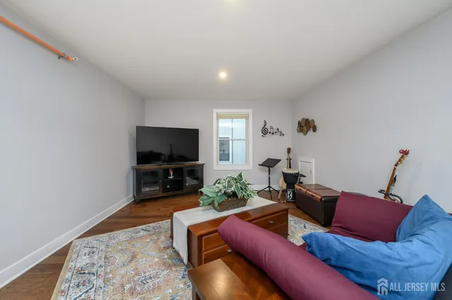 a sitting area with a lamp on table and a rug