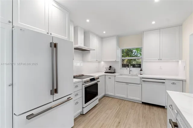 a kitchen with white cabinets and white appliances