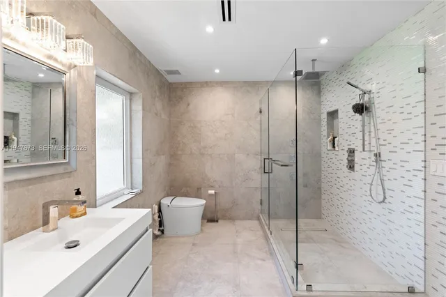 a bathroom with a sink a toilet and shower