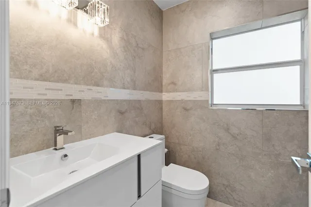 a bathroom with a sink a toilet and a window