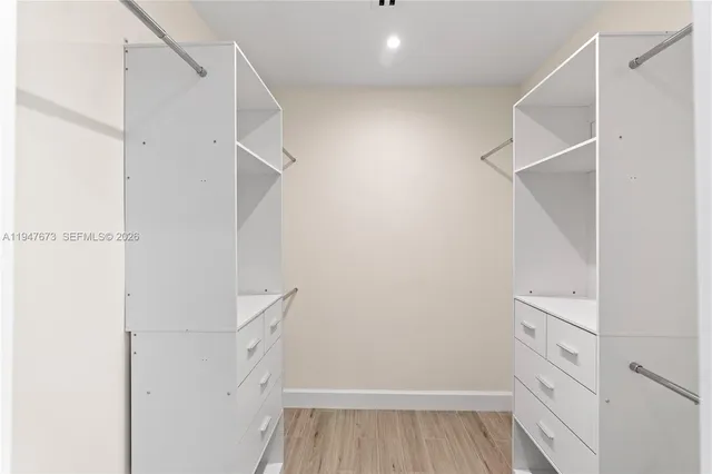 a view of walk in closet with empty racks