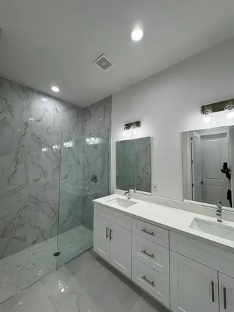 a bathroom with a double vanity sink mirror and shower