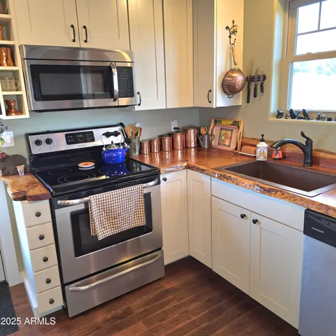 a kitchen with granite countertop white cabinets and appliances