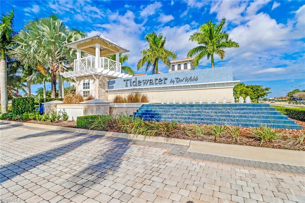 10588 Jackson Square Drive Estero, FL 33928 - Photo 28 of 50 a view of a house with a yard and a bench under an umbrella