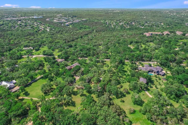 a view of a green field with lots of bushes