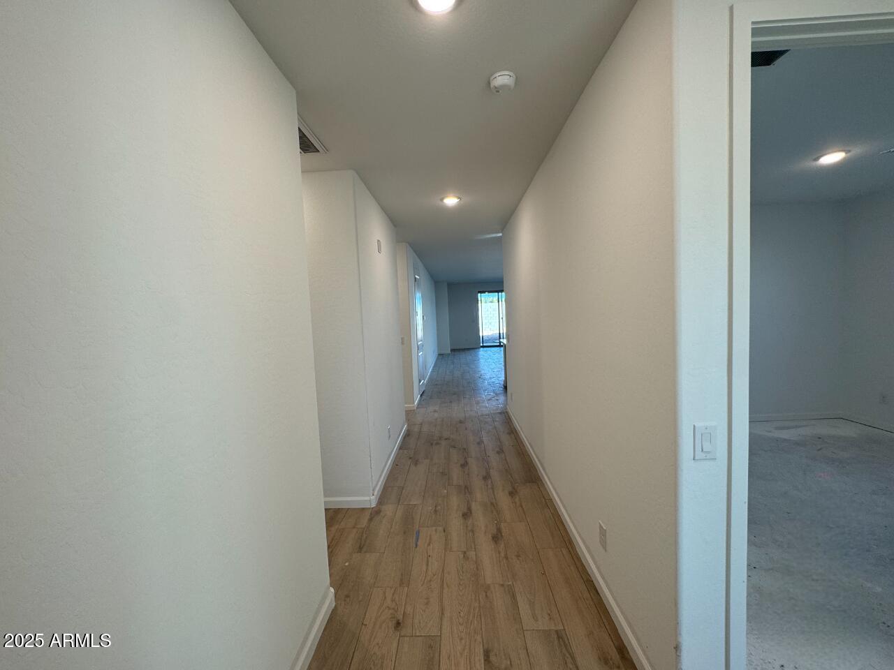 15720 West Camden Avenue Waddell, AZ 85355 - Photo 3 of 32 a view of a hallway with wooden floor