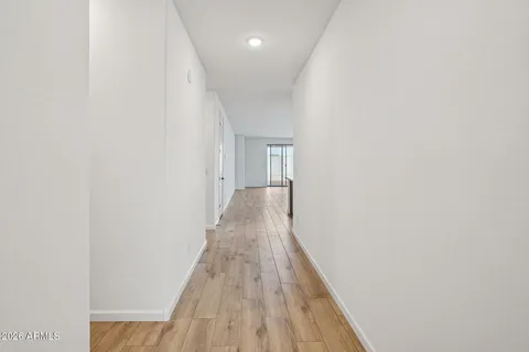a living room with lots of furniture kitchen view and a wooden floor