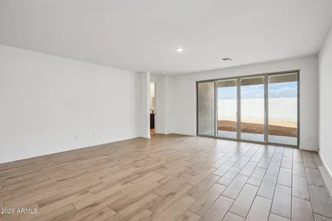 a large white kitchen with wooden floors and stainless steel appliances
