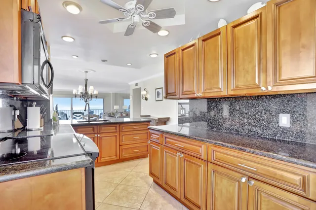 a dining hall with stainless steel appliances granite countertop a stove and a sink