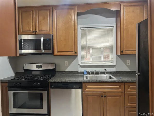 a kitchen with stainless steel appliances granite countertop white cabinets and black stove top oven with granite countertops