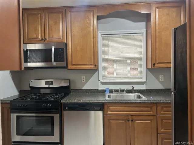 a kitchen with stainless steel appliances granite countertop white cabinets and black stove top oven with granite countertops