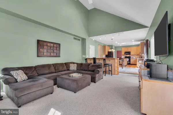 a living room with furniture kitchen view and a window
