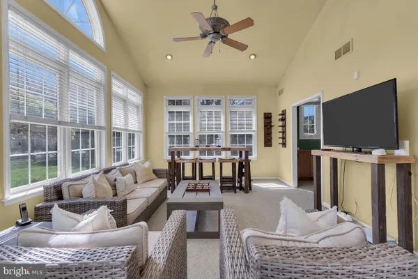 a living room with furniture a flat screen tv and a large window