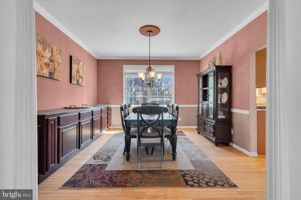 a dining room with furniture a chandelier and wooden floor