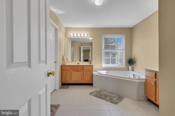 a large bathroom with a tub a sink and mirror