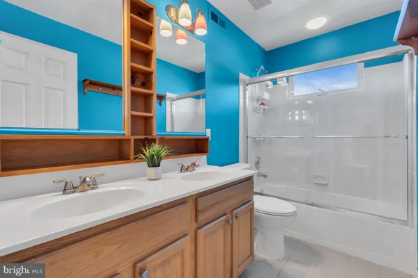 a bathroom with a granite countertop sink a toilet and shower