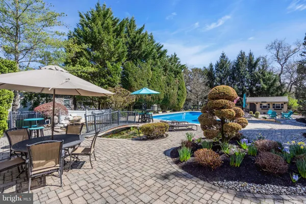 a swimming pool with outdoor seating and barbeque oven