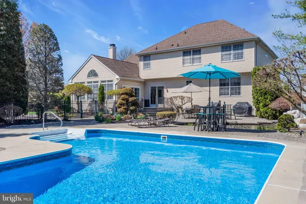 a front view of house and yard with swimming pool and furniture