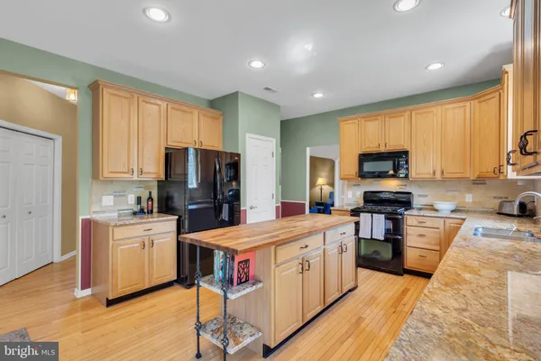 a large kitchen with stainless steel appliances lots of counter space and wooden floor