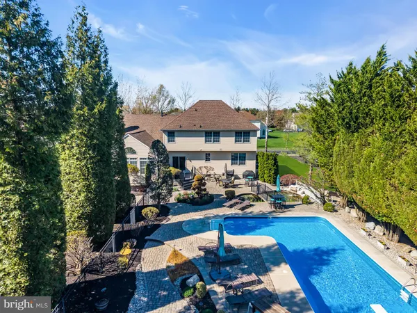 a view of swimming pool with outdoor seating and trees in the background