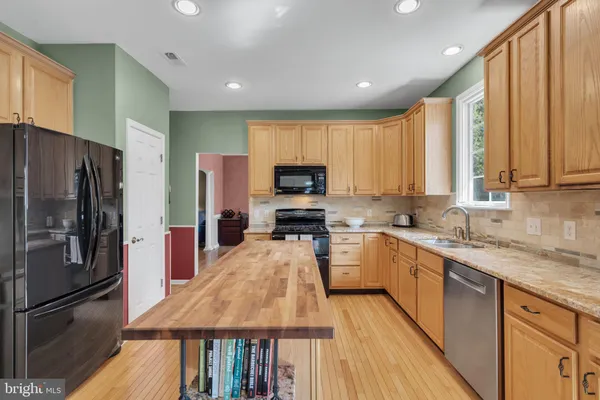 a kitchen with a refrigerator a sink and wooden cabinets