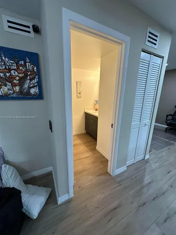 a view of a hallway with wooden floor and a large window