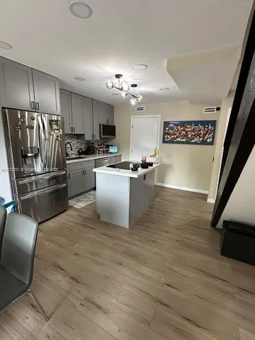 a kitchen with stainless steel appliances granite countertop a refrigerator sink and stove