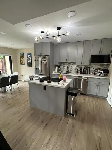 a kitchen with sink a microwave and cabinets