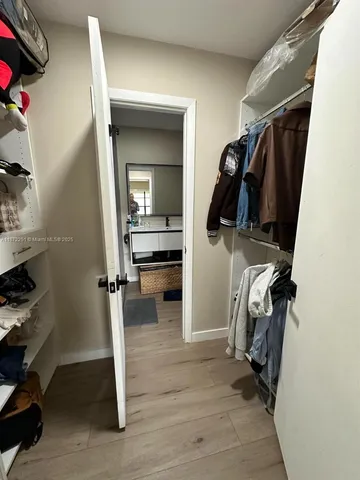 a view of walk in closet with clothes and shoes