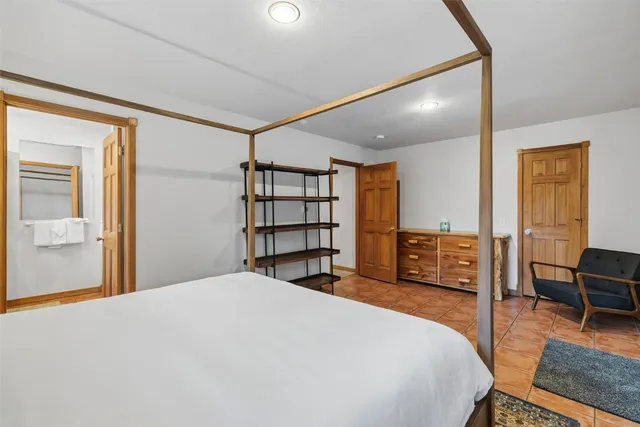 a bedroom with a bed a window and painting on the wall