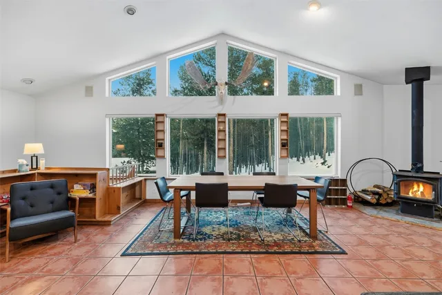 a living room with furniture a rug and a floor to ceiling window