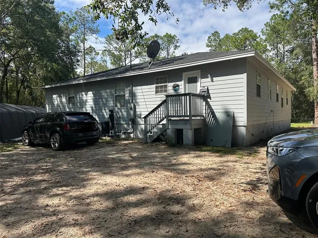 a view of a backyard with parked cars