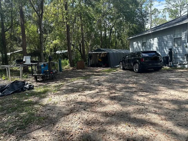 a view of a house with backyard and trees