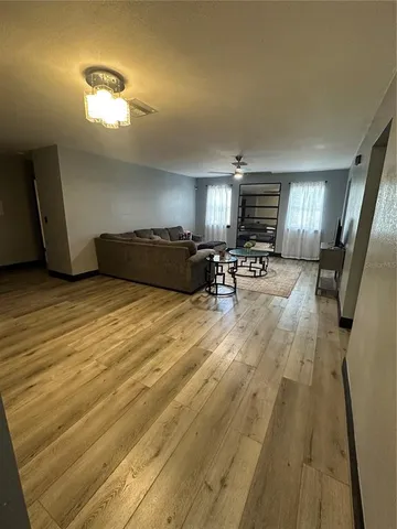 a kitchen with stainless steel appliances kitchen island granite countertop a refrigerator a stove a sink dishwasher and wooden cabinets with wooden floor