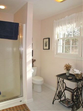 256 Sandpiper Lane Tisbury, MA 02568 - Photo 19 of 25 a bathroom with a toilet a sink and a window